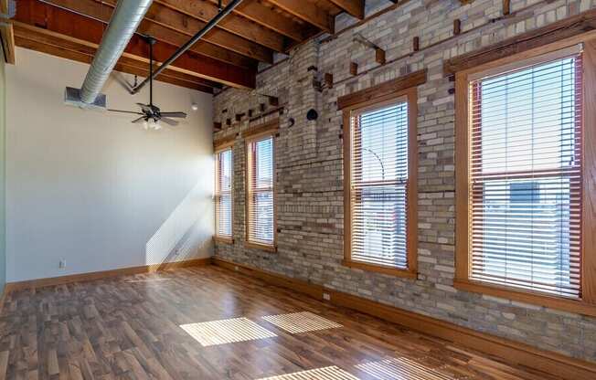 A room with wooden floors and a brick wall.