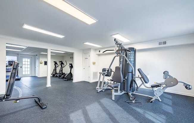 A gym with a variety of equipment including a treadmill, stationary bike, and weight machines.