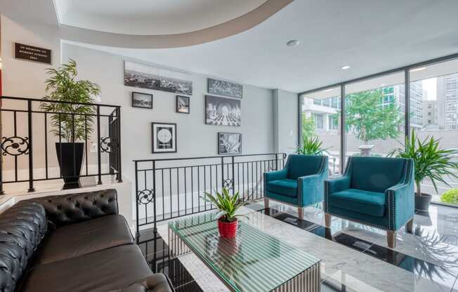 a living room with a couch and chairs and a balcony