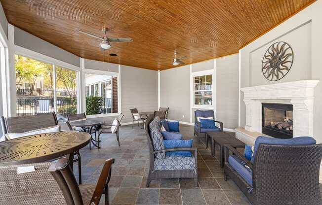 a patio with tables and chairs and a fireplace