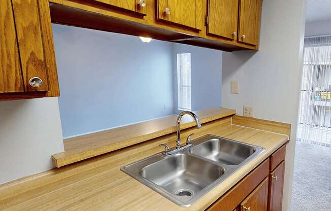 A kitchen with wooden cabinets and a stainless steel sink.