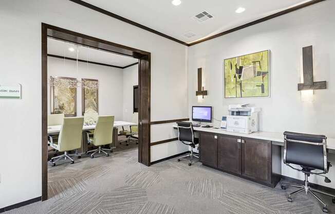 A business center with a computer, printer, and conference room at GreenVue Apartments in Richardson, TX