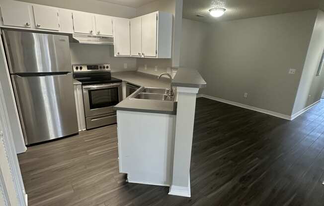 an open kitchen with white cabinets and stainless steel appliances