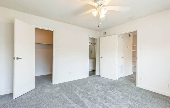 A room with a ceiling fan and carpeted floor.