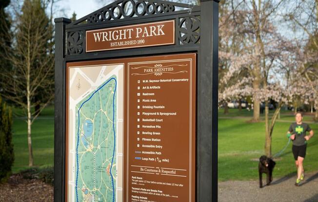 a man walks his dog past a wright park sign