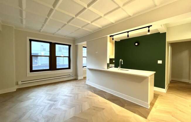 an empty room with a sink and a green wall and a window