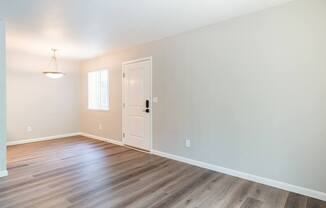 A room with a wooden floor and a white door.