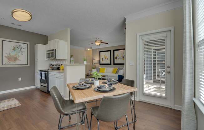 A kitchen with a table and chairs in front of a window.