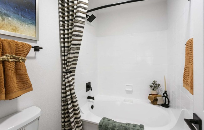 A bathroom with a white tub and a shower curtain.