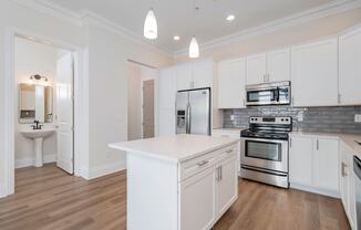 a kitchen with white cabinets and stainless steel appliances