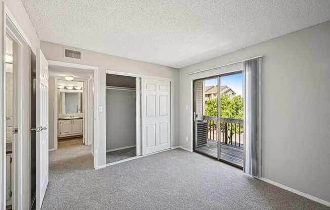 an empty living room with sliding glass doors to a balcony