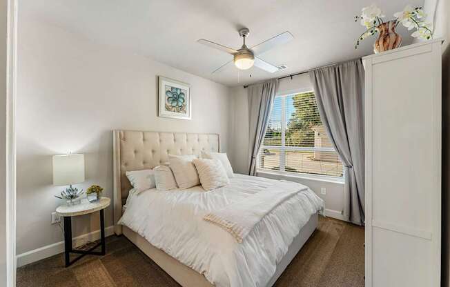 A bedroom with a large bed and a ceiling fan.