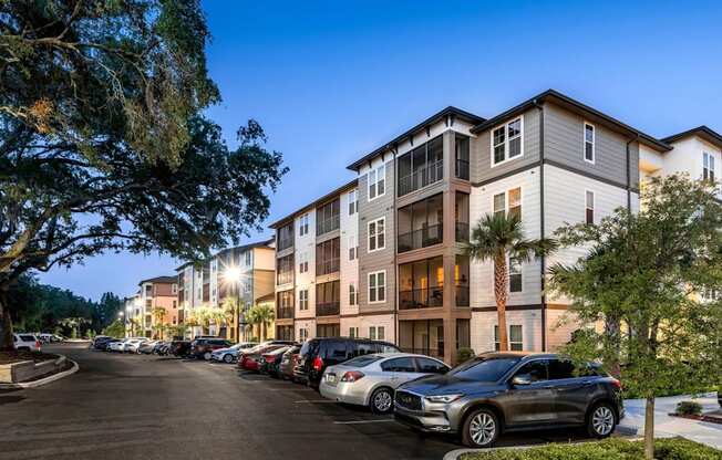 A parking lot with cars and a building in the background.