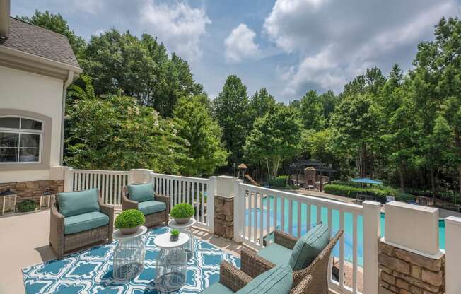 a patio with chairs and a table on a balcony