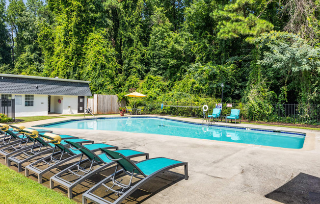 a swimming pool with deck chairs next to a resort style pool