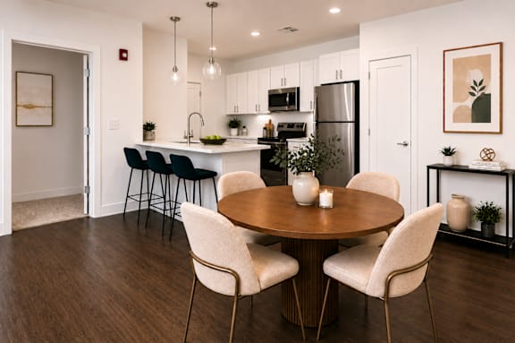 A modern kitchen with a dining table set for two.