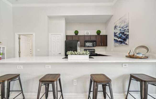 a kitchen with bar stools and a counter top with stools