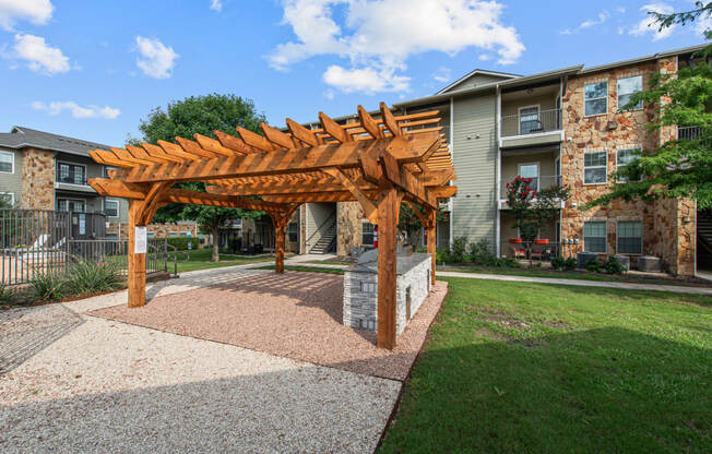 a wooden pergola in front of an apartment building