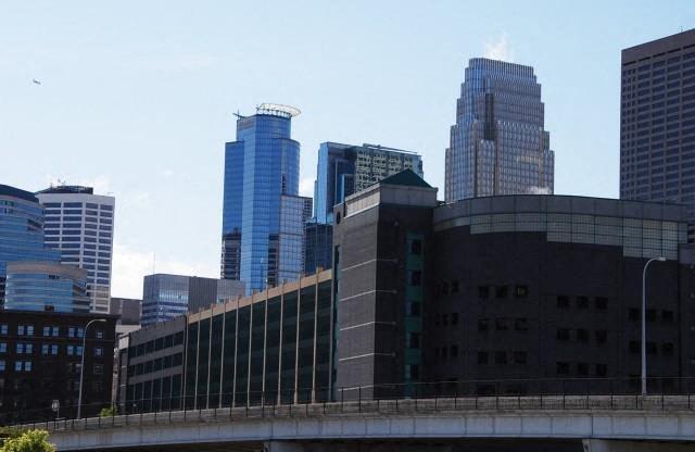 A cityscape with a bridge in the foreground and tall buildings in the background.