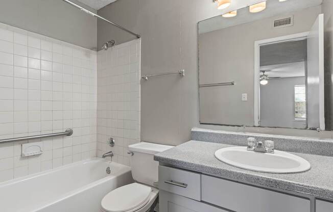 A white toilet sits next to a white sink in a bathroom.