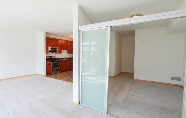 A room with a carpeted floor and a glass door leading to another room.
