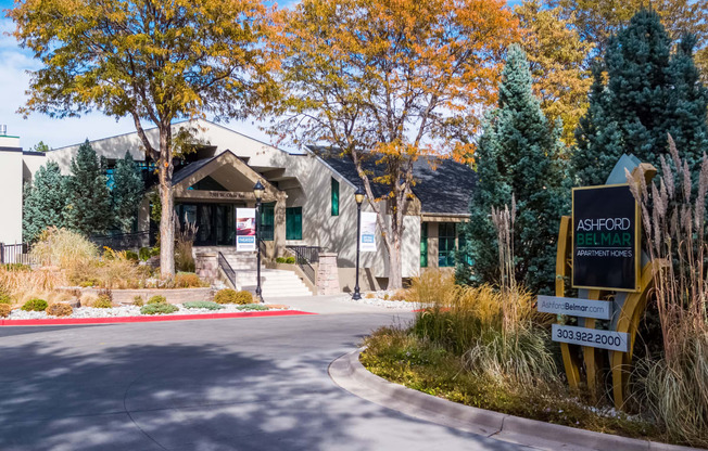 the front of a building with a street sign in front of it at Ashford Belmar Apartments, Lakewood, CO 80226