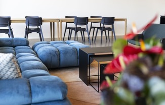 a living room with blue couches and a table with chairs at Analog PDX Apartments, Oregon 97227