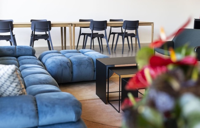 a living room with blue couches and a table with chairs at Analog PDX Apartments, Oregon 97227