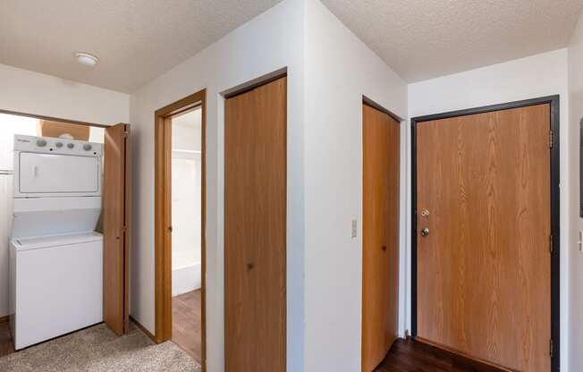 an empty room with three doors and a laundry room. Fargo, ND Westview Towers Apartments