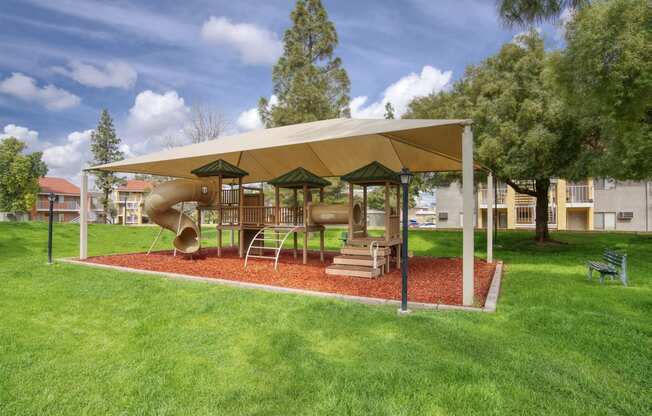 a playground with a slide and climbing equipment in a park