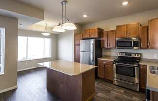 an empty kitchen with wooden cabinets and stainless steel appliances