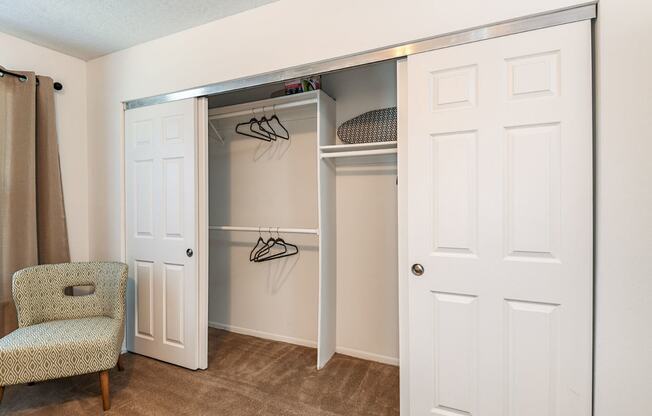 a closet with a door and a chair in a room