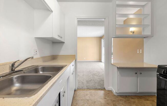 a kitchen with white cabinets and a stainless steel sink