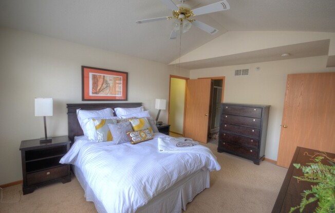 a bedroom with a large bed and a ceiling fan