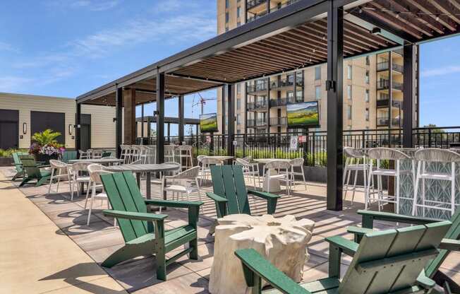 a patio with chairs and tables and a building in the background