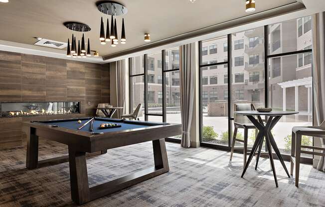 a room with a pool table and a fire place at The Griffin Royal Oak, Royal Oak, MI