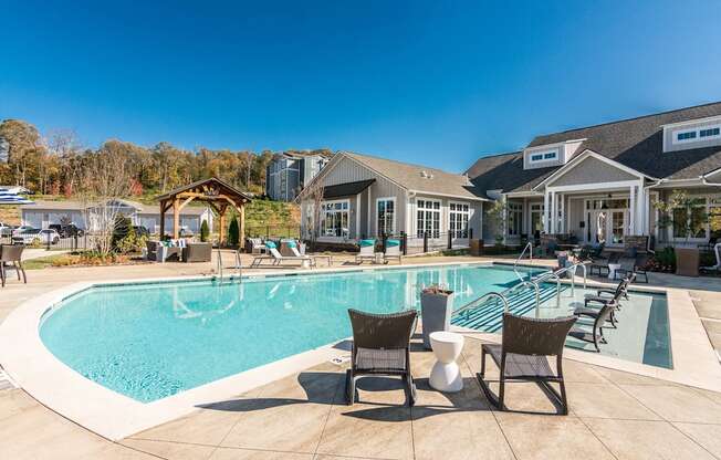 a large swimming pool with chairs and a house in the background at Village at Westland Cove Apartments, Knoxville, 37922