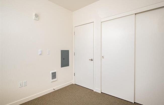 a bedroom with white walls and white doors and carpet