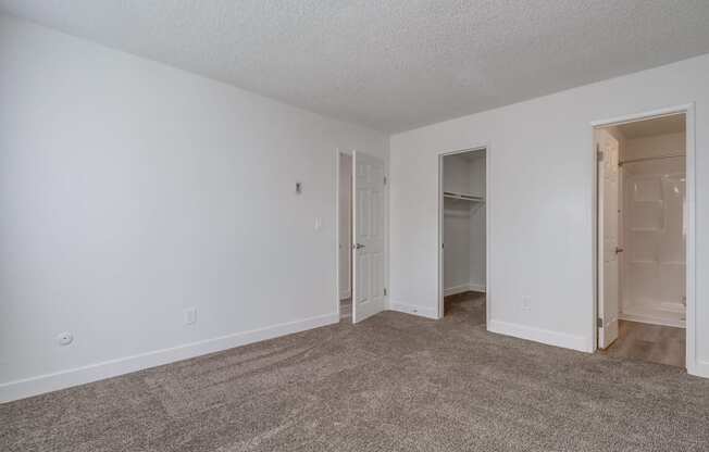 a bedroom with white walls and carpet