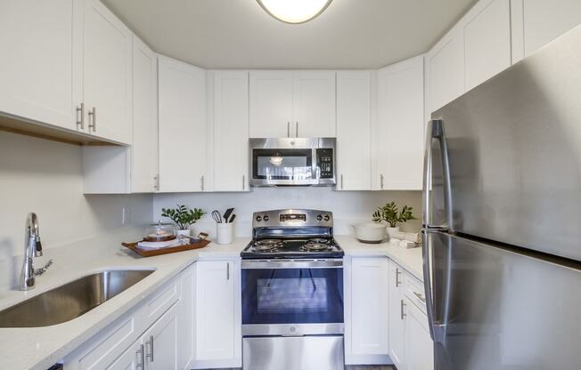 a kitchen with white cabinets and stainless steel appliances