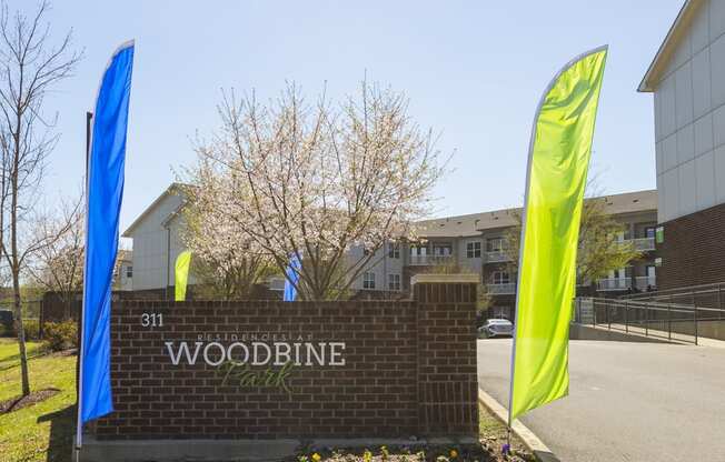 a sign for woodbine park with flags in front of it