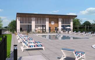 A poolside area with sun loungers and a building in the background.