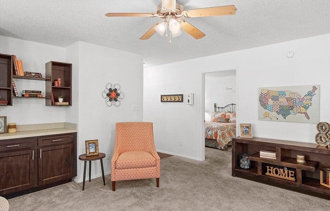 a living room with a ceiling fan    and a bedroom