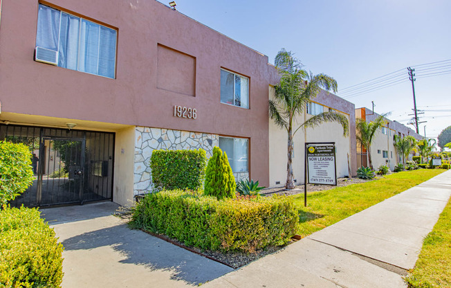 a pink building with a sign on it and a sidewalk