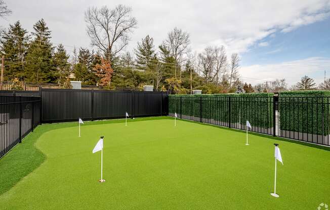 A golf course with green grass and white flags.
