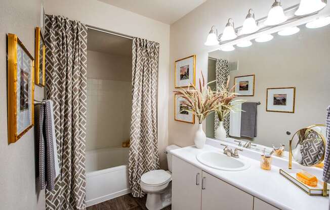 A bathroom with a white sink, toilet, and a mirror.