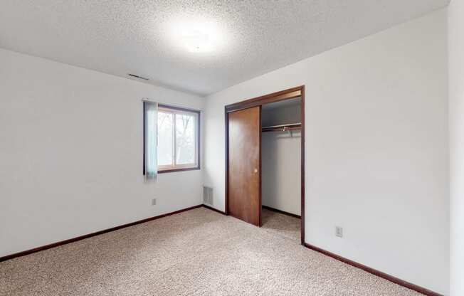 an empty living room with a door to a closet