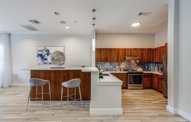 A kitchen with a bar area and two stools.